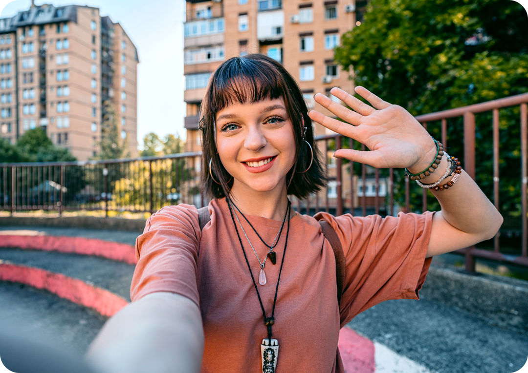 A women taking selfie with many tall buildings on the background