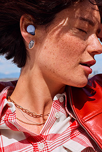 Close-up picture of a woman's face, with her eyes closed, wearing Pixel Buds 2a in Iris colour