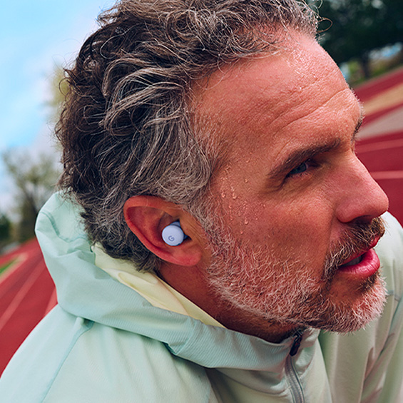 Close-up image of a man wearing the Pixel Buds 2a in Iris colour