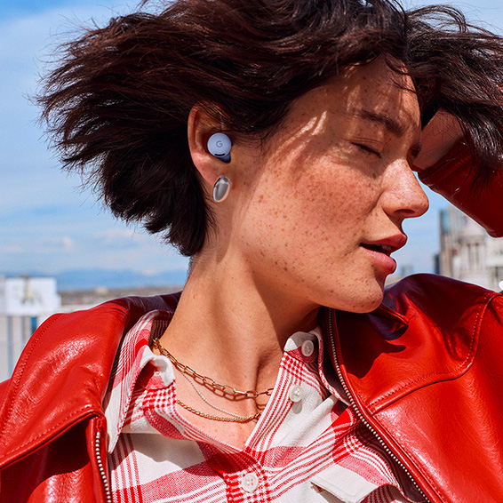 Close-up picture of a woman's face, with her eyes closed, wearing Pixel Buds 2a in Iris colour