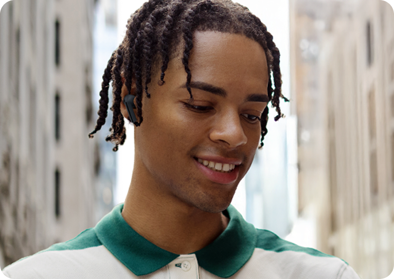 A man on a city street wearing Buds3 FE to have a clear conversation